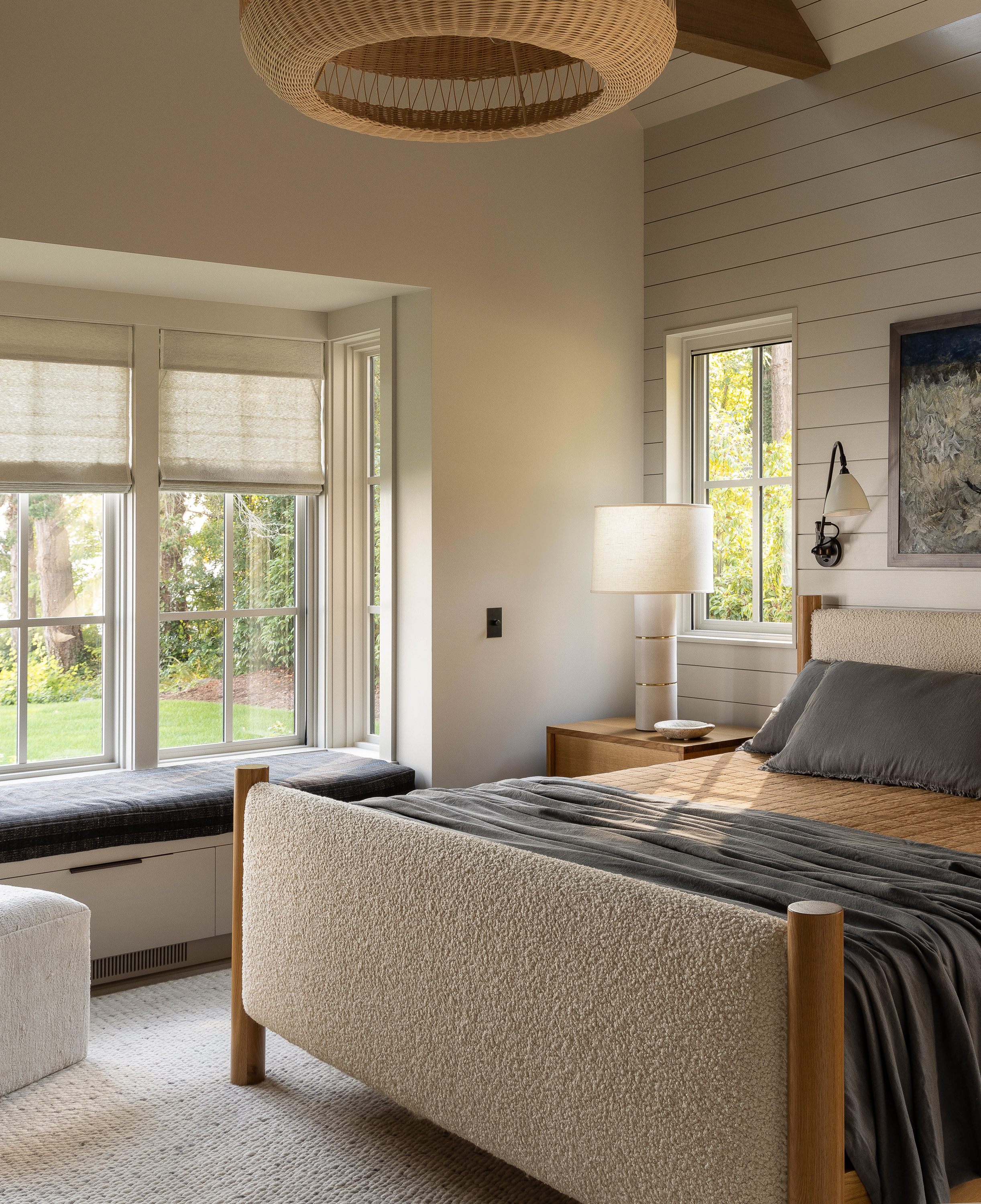 The primary bedroom is a simple, tranquil space with a window seat that extends into the landscape, offering views of the sound beyond.