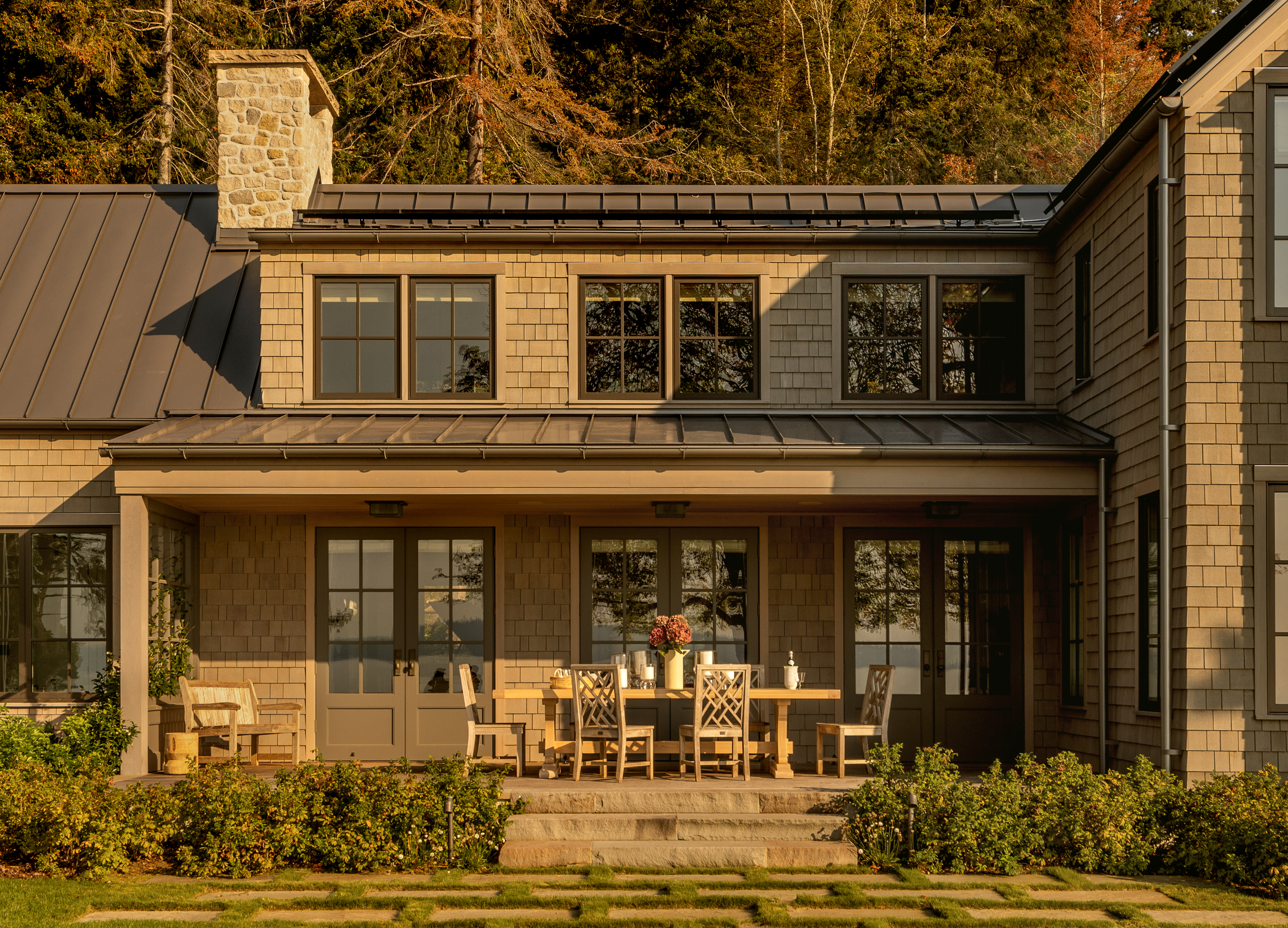 Exterior image highlighting the dining area outside the living room, where the design seamlessly connects indoor and outdoor living spaces, offering a picturesque setting for alfresco dining and entertaining.
